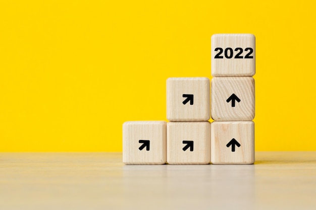 2022 año nuevo. tendencia de crecimiento del interés. Cubos sobre un fondo amarillo. Simboliza el crecimiento. Concepto de negocio. Copie el espacio.