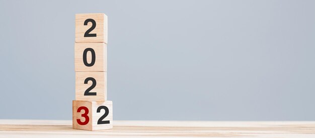 2022 cambio a 2023 bloques de cubos de madera en el fondo de la mesa Resolución de revisión del plan objetivo inicio final año y conceptos de vacaciones de Año Nuevo