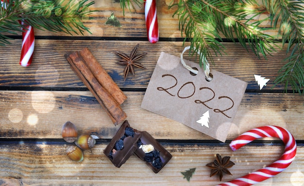 2022 escrita em um papelão colocado sobre uma mesa com doces e decoração de natal