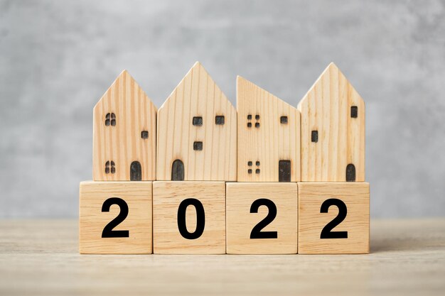 2022 Feliz Ano Novo com modelo de casa na mesa. Conceitos de banco, imobiliário, investimento, financeiro, poupança e resolução de ano novo