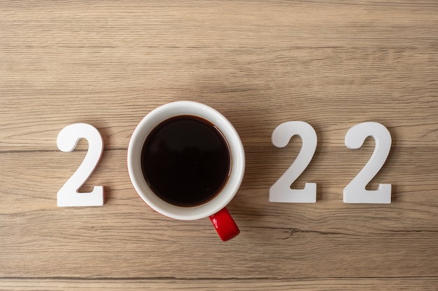 2022 Frohes neues Jahr mit Kaffeetasse und Weihnachtsdekoration auf Holztischhintergrund. Neuer Start, Lösung, Countdown, Ziele, Plan, Aktion und Missionskonzept