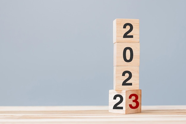 2022 muda para 2023 blocos de cubo de madeira no fundo da mesa Plano de resolução revisão meta início final do ano e conceitos de feriado de Ano Novo