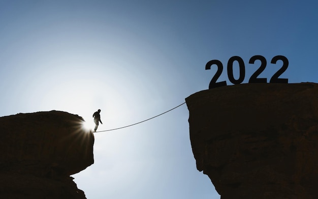 Foto 2022 neujahrskonzept silhouette ein mann zu fuß auf einem seil bis 2022