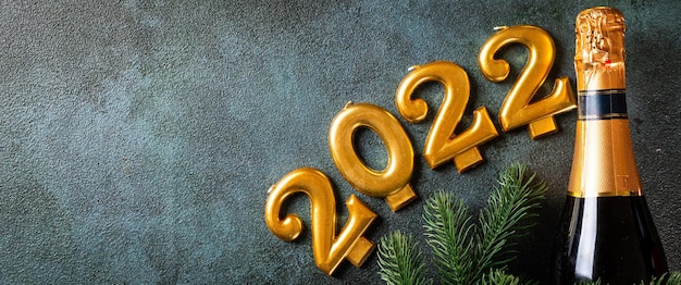 2022-Nummer mit Champagnerflasche und Dekor. Frohes neues Jahr und festliches Konzept. Horizontale Ansicht von oben, Exemplar. Neues Jahr flach. Weihnachts-Flatlay. Neues Jahr 2022. Konzept des neuen Jahres.