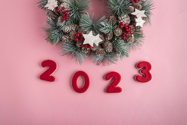 2023 ano novo de pão de gengibre e guirlanda de natal em fundo rosa feliz ano novo 2023