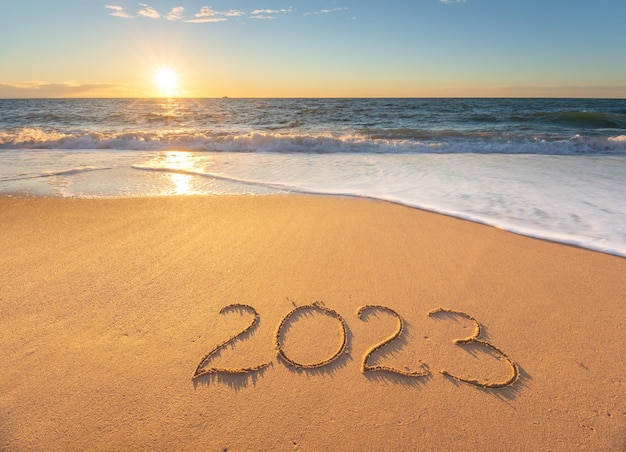 2023 año en la orilla del mar durante la puesta de sol