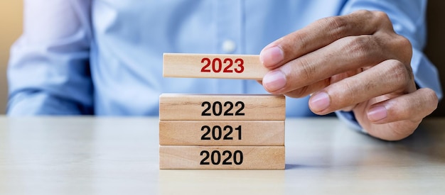 2023 bloque sobre 2022 y 2021 edificio de madera sobre fondo de mesa Planificación empresarial Gestión de riesgos Resolución estrategia solución objetivo Año nuevo Nuevo usted y conceptos de felices fiestas