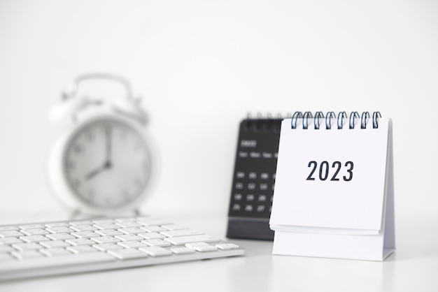 2023 Business Kalender Tastatur und Uhr auf dem Bürotisch am Neujahrstag Erstellen Sie einen Arbeitsplan für den Jahresbeginn Konzept über Celebration Business Christmas New Year