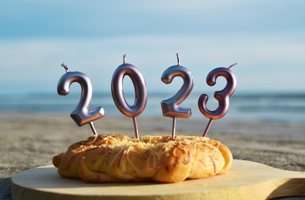 2023 Feliz Ano Novo com pão e velas na praia