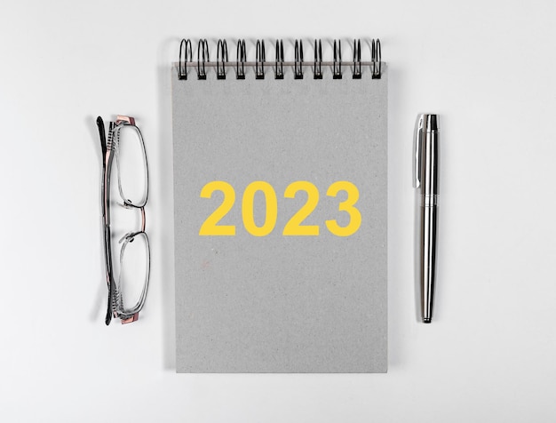 2023 neujahrsplanung auf planer tagebuch stift und brille