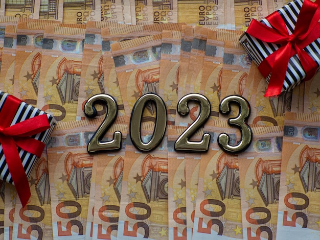 2023 und Geschenkboxen auf dem Hintergrund von fünfzig Euro-Banknoten