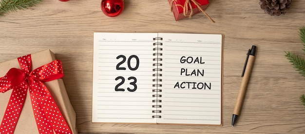 2023 Zielplan Aktion mit Notizbuch Weihnachtsgeschenk und Stift auf Holztisch Weihnachten Frohes Neues Jahr Auflösung Aufgabenlistenstart und Strategiekonzept