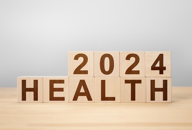 2024 concepto de salud cambio de cubo de madera año 2023 a 2024 fondo gris espacio de copia cambio de cubo de madera en el escritorio banner de fondo gris