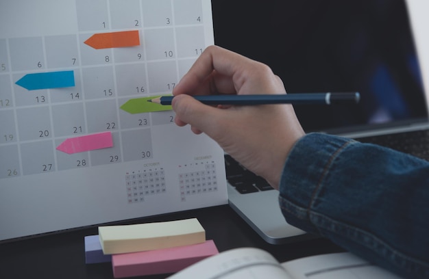 2024 Planificador de eventos horario plan de la agenda en el horario evento mujer de negocios chequeo planificador tomando nota en el escritorio del calendario con computadora portátil en la mesa de la oficina calendario plan de eventos planificación del trabajo