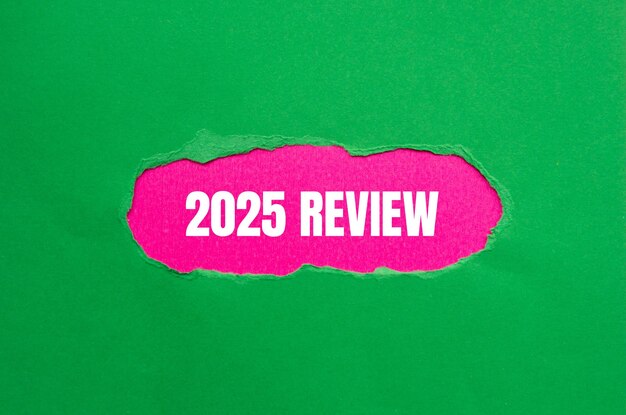 2025-Rezensionsbotschaft auf zerrissenem grünem Papier mit rosa Hintergrund Konzeptuelles 2025-R rezensionssymbol Kopierraum
