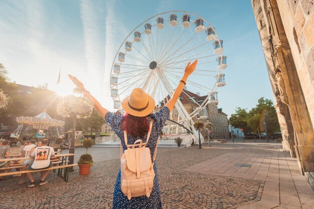 Foto 24 de julio de 2022 osnabruck alemania chica viajera en una feria de diversiones con una noria en la antigua ciudad europea en la plaza