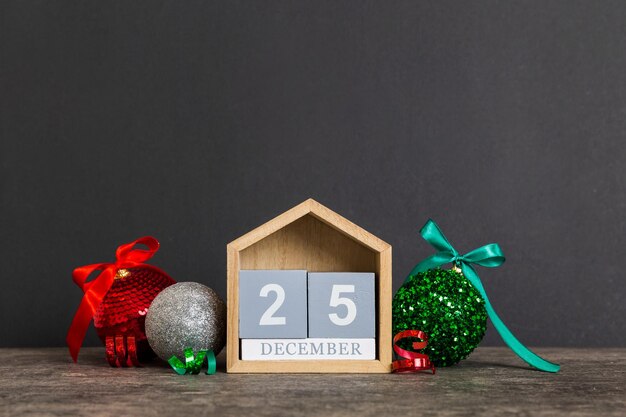 25 de dezembro composição de Natal em fundo colorido com um calendário de madeira com uma caixa de presentes brinquedos bauble espaço de cópia