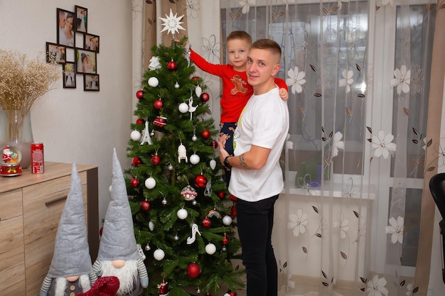 25. Dezember 2021 Vinnytsia Ukraine Vater und Sohn zusammen in der Nähe des Weihnachtsbaums