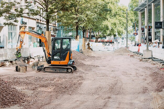 29 de julho de 2022 Colônia Alemanha Pequena escavadeira trabalhando em um canteiro de obras na rua da cidade Trabalho e emprego no setor industrial