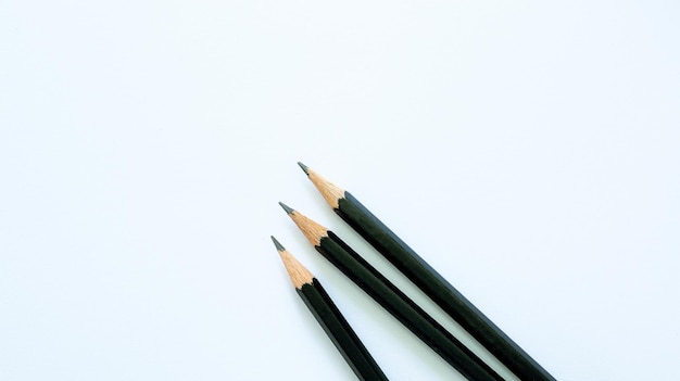 2B-Bleistift auf weißem Papier, schwarze Stifte auf farbigem Papierhintergrund mit Kopierraum für Ihre