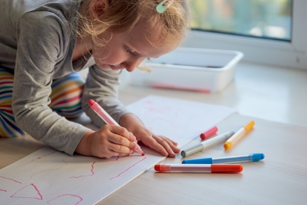 3 años niña artes creativas. El niño come una foto. El jardín de infancia y el preescolar cerraron durante Covid-19, educación en línea, educación en el hogar. Niña pequeña estudiando en casa, aprendizaje en casa.