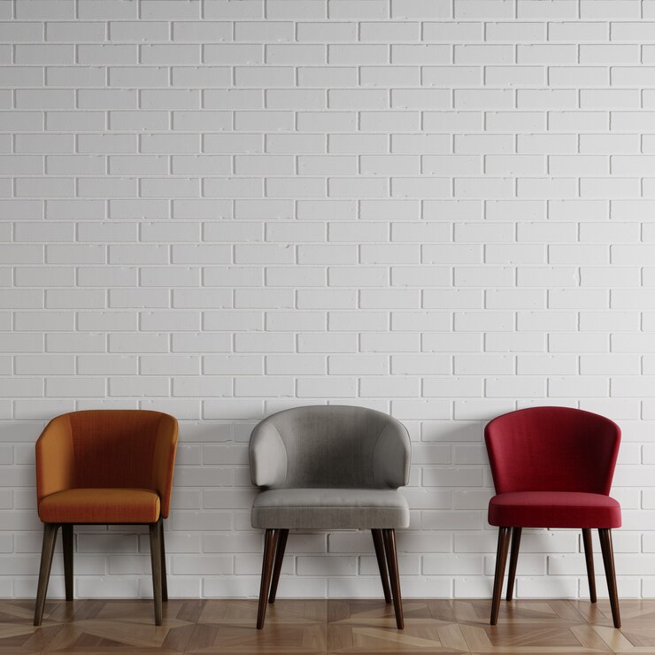 3 cadeiras diferentes em estilo moderno, em frente a parede de tijolos brancos com copyspace