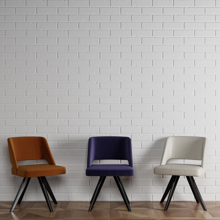 3 cadeiras diferentes em estilo moderno, em frente a parede de tijolos brancos com copyspace