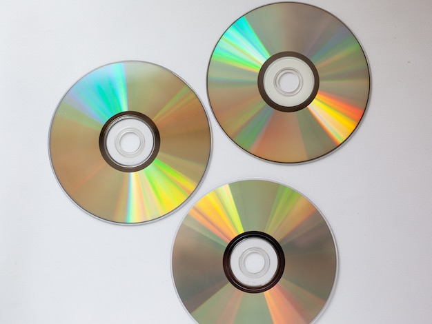 3 discos compactos cd dispersos con música en un primer plano de fondo blanco