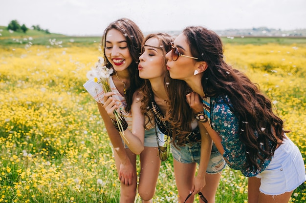 3 hermosa chica hippie en un campo de flores amarillas