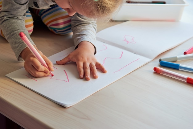 3 Jahre Mädchen zeichnet ein Bild. Kind zu Hause, Kindergarten und Vorschule während Covid-19 geschlossen