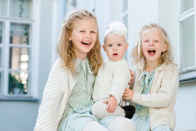 3 kleine Mädchen mit hellem Haar umarmen Schwesterliebe