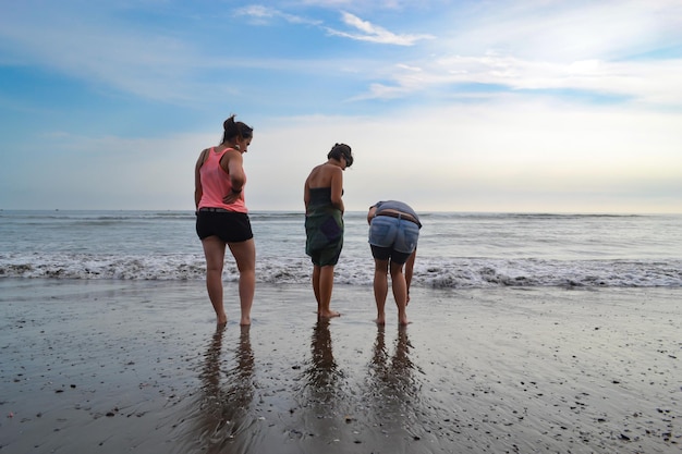 3 mulheres em frente à costa de uma praia ao pôr do sol Oceano Pacífico Peru