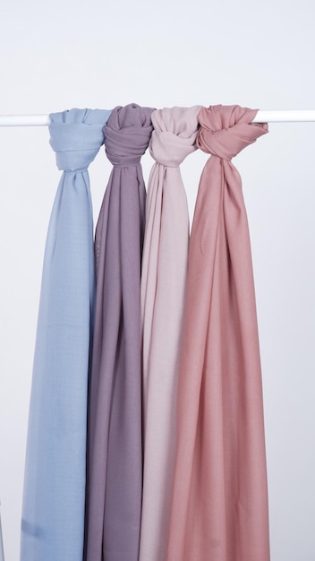 3 variantes de hijab pendurado com um modelo de corda com fundo branco.
