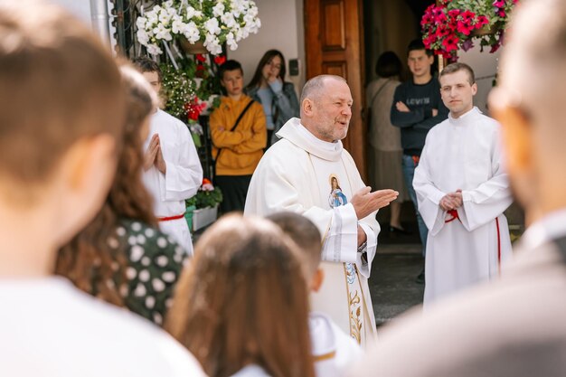 300523 Vinnitsa Ucrânia, um padre católico fala diante de crianças que se preparam para a primeira comunhão e as abençoa