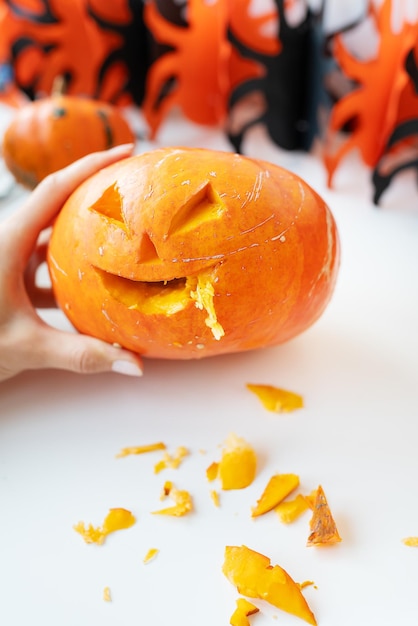 31 de outubro feriado de Halloween O rosto esculpido de uma abóbora em um fundo laranja e preto