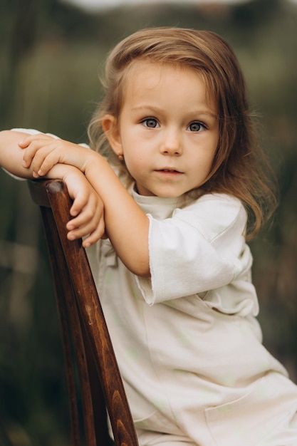 310722 Vinnitsa Ucrania bonito retrato de una niña de 3 años con botas de goma en tiempo nublado en un fondo natural junto al río