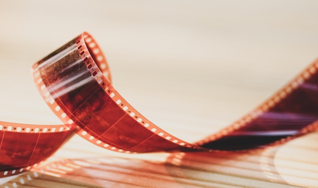 35mm-Fotografiefilm, Farbnegativfilm auf Holztisch-Hintergrund, Vintage-Ausrüstung für alte Filmproduktion, Filmproduktion, Konzept der Unterhaltungsindustrie, Nahaufnahme