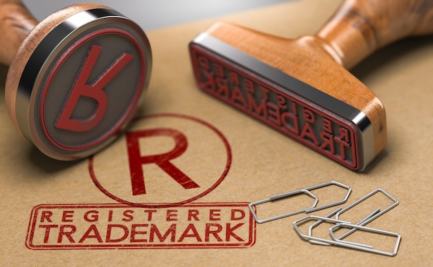 3D-Darstellung von zwei Stempeln mit dem Text eingetragene Marke und das Symbol R über braunem Papierhintergrund. Konzept der Markenregistrierung