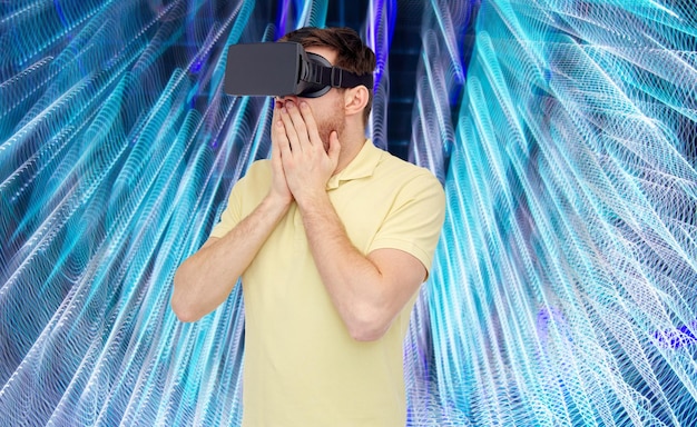 Foto 3d-technologie, virtual reality, entertainment und people-konzept - glücklicher junger mann mit virtual-reality-headset oder 3d-brille, der ein spiel auf spiralförmigem neonlichthintergrund spielt