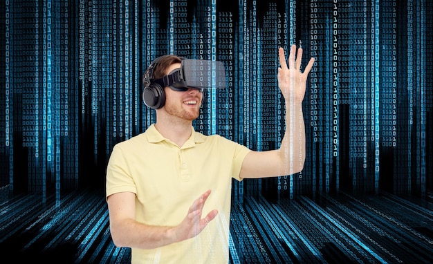 3D-Technologie, Virtual Reality, Entertainment und People-Konzept - glücklicher junger Mann mit Virtual-Reality-Headset oder 3D-Brille, der ein Spiel über Binärcode-Hintergrund spielt