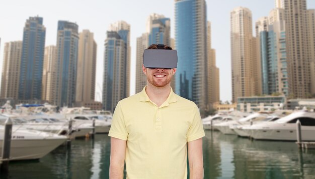 3D-Technologie, Virtual Reality, Reise-, Unterhaltungs- und People-Konzept - glücklicher junger Mann mit Virtual-Reality-Headset oder 3D-Brille über dem Straßenhintergrund der Stadt Dubai