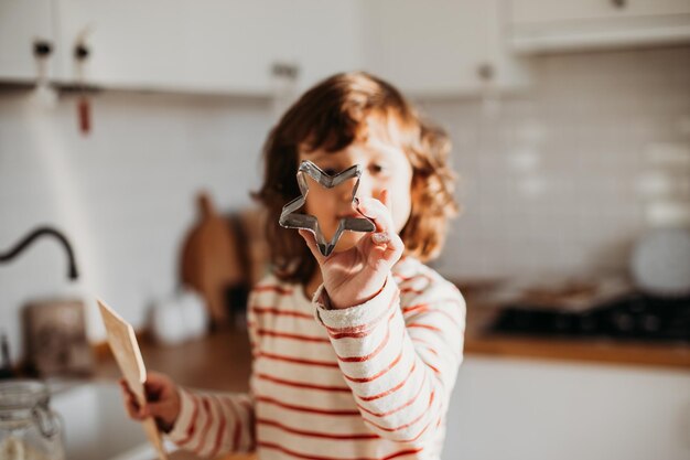 4 anos linda garota fazendo biscoitos de natal tradicionais