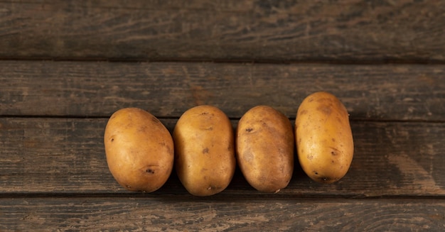 4 gelbe Kartoffeln auf einer Holzstruktur Konzept Kartoffelgemüsegarten Landwirtschaft Landwirtschaft