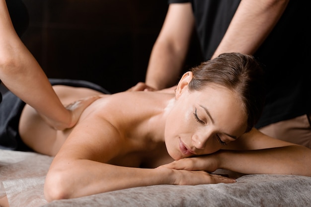 4-Hand-Massage im Spa. Zwei Masseure machen vier Hände entspannende Massage mit Öl für Mädchen. Entspannung. Manuelle Therapie.