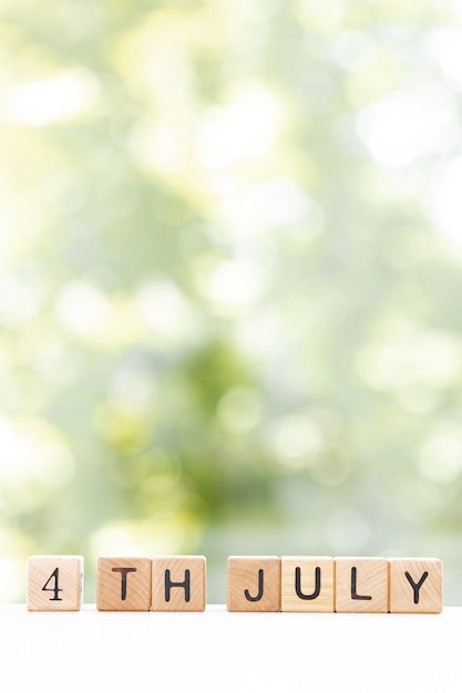 Foto 4 de julio diseño de fecha con cubo de calendario sobre mesa de madera y fondo verde