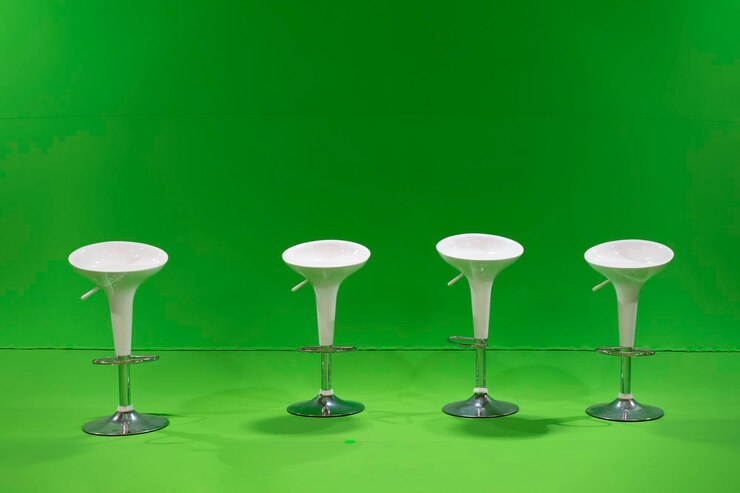 Las 4 sillas de estudio blancas se colocan frente a una pantalla verde con luz de estudio alrededor