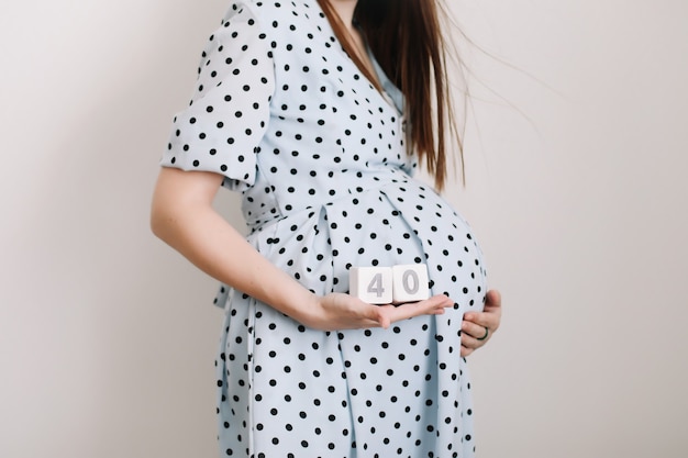 40 semanas de gravidez. mulher grávida tocando a barriga. mulher feliz, gravidez, maternidade, cuidados com o corpo. esperando um bebê próximo.