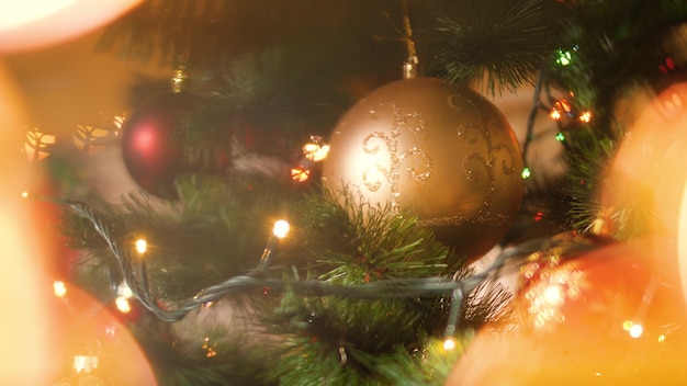 4k abstraktes Filmmaterial von geschmücktem Weihnachtsbaum mit Kugeln und Girlanden. Leuchtende LED-Leuchten im Vordergrund