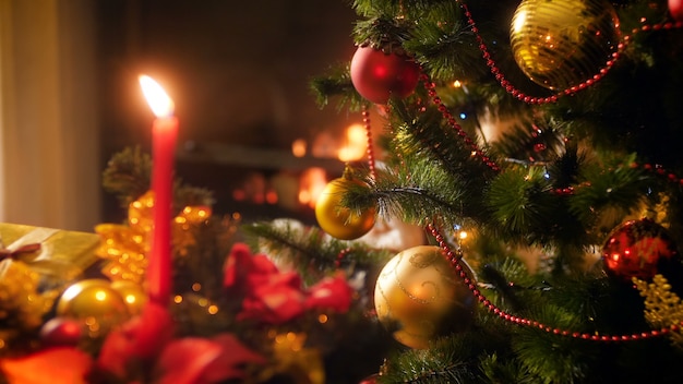 4K-Aufnahmen von schön dekoriertem Weihnachtsbaum mit leuchtenden Lichtern und brennendem Feuer im Kamin. Perfekte Aufnahme für Winterfeiern und Feiertage
