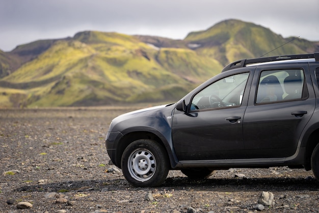 4x4 Auto geparkt abseits der Straße auf dem schwarzen Lavafeld auf dem Weg nach Landmannalaugar, Island.